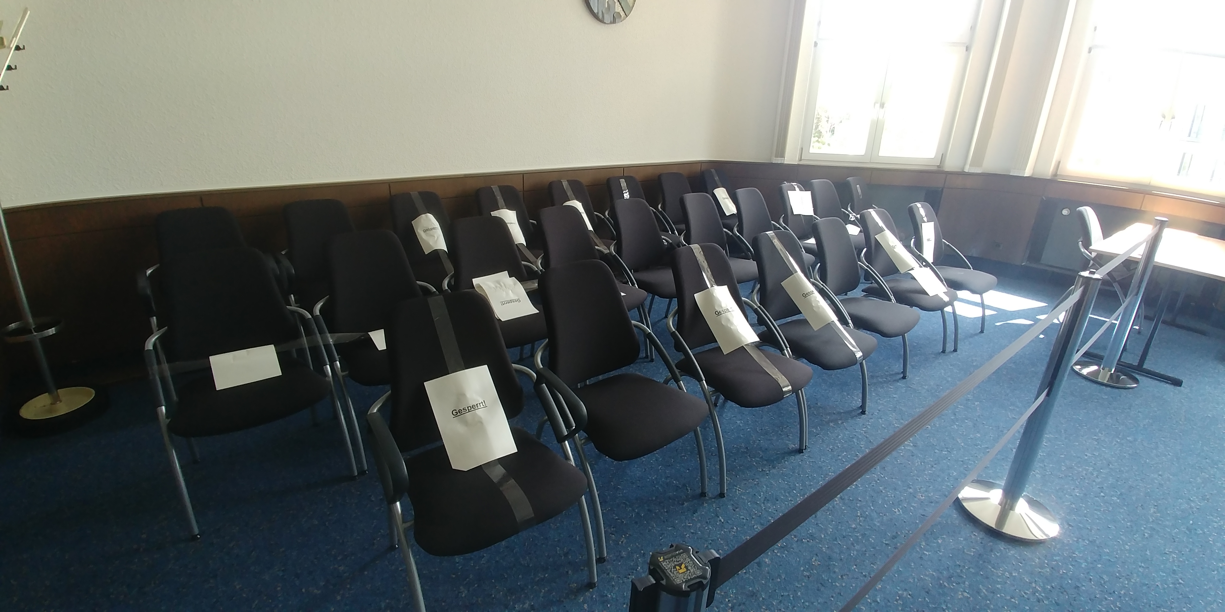 Bild von einem Sitzungssaal mit gesperrten Stühlen wegen Corona